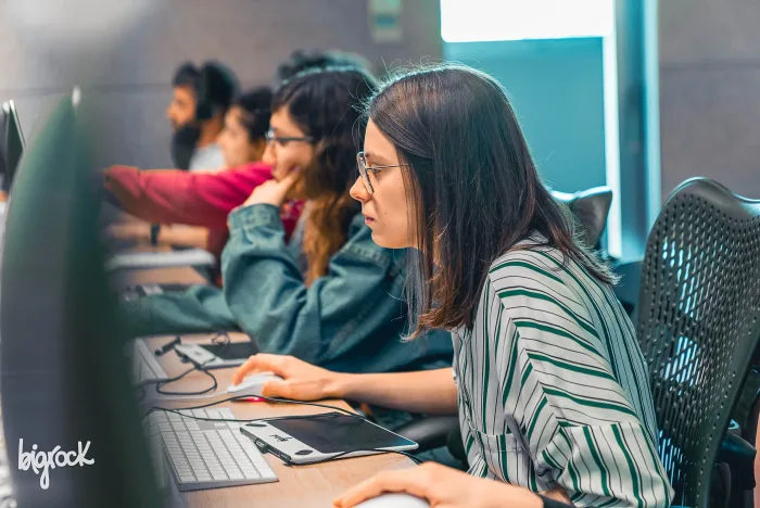 Studentessa con occhiali al lavoro al computer in un laboratorio di computer grafica