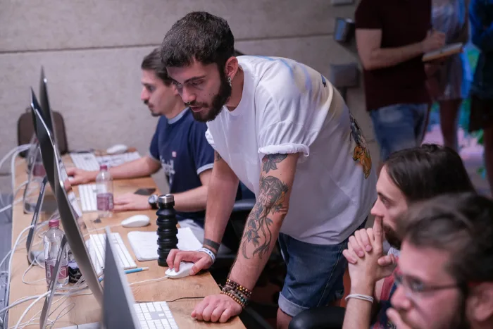 Studente in piedi segue il lavoro dei compagni alle postazioni
