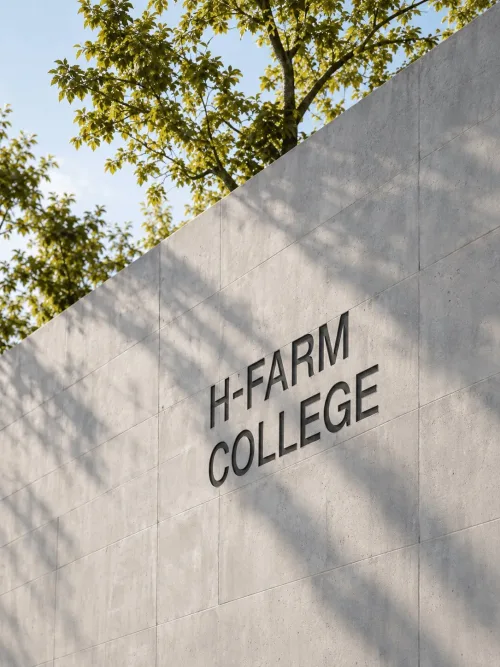 Scritta H-FARM College su una parete in cemento