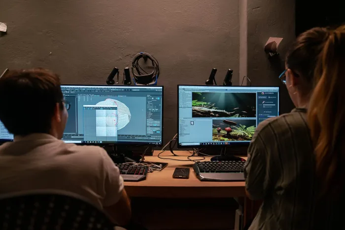 Studenti alle prese con modellazione 3D e rendering su postazioni a doppio monitor