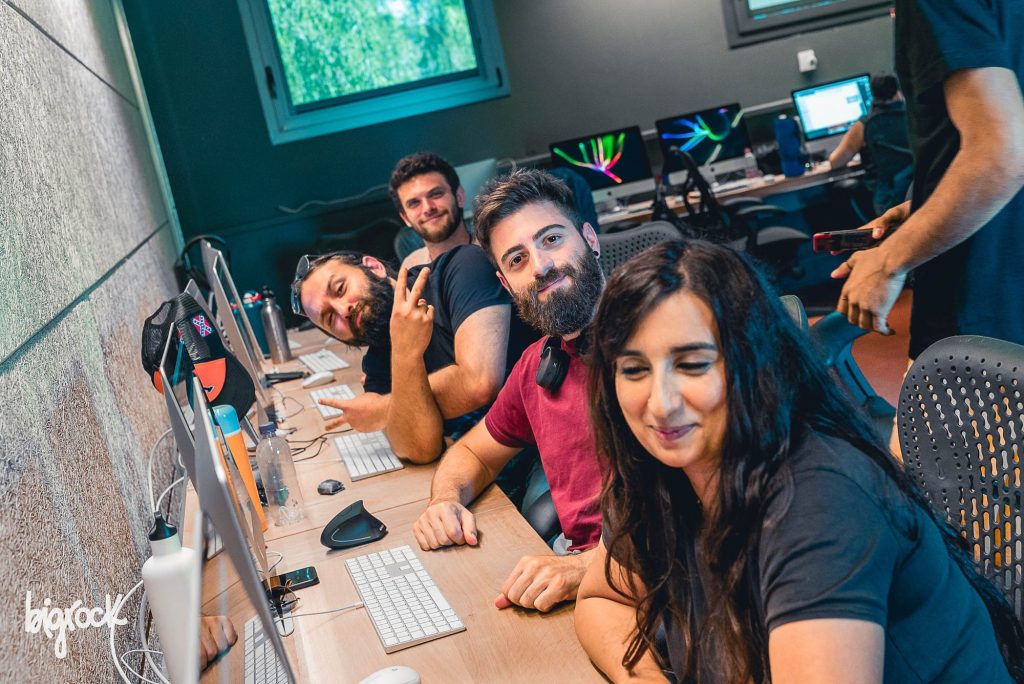 Studenti sorridenti alle postazioni in aula durante una lezione di animazione 3D