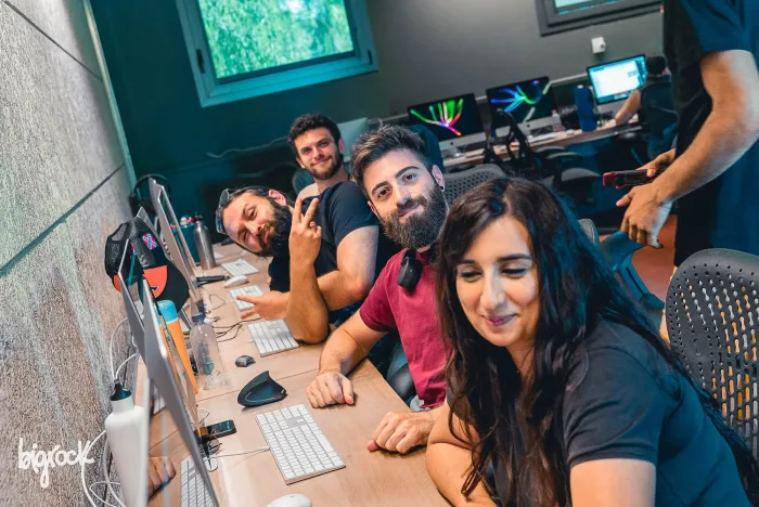 Studenti sorridenti alle postazioni in aula durante una lezione di animazione 3D