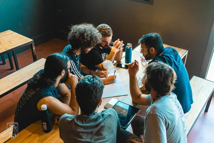 Gruppo di studenti al tavolo durante una sessione di progettazione di un videogioco