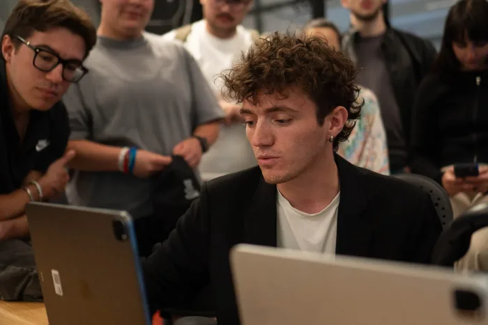 Studenti seguono un compagno che presenta un progetto su tablet
