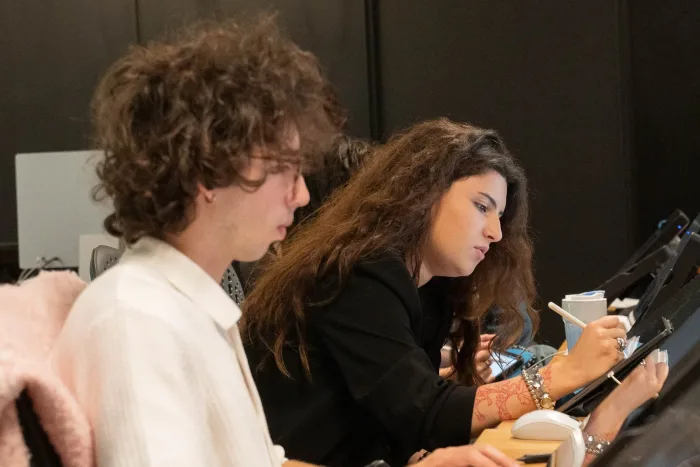 Studenti concentrati su schizzi digitali con penna e tavoletta