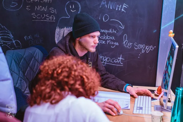 Studenti al lavoro davanti a una lavagna con disegni e scritte